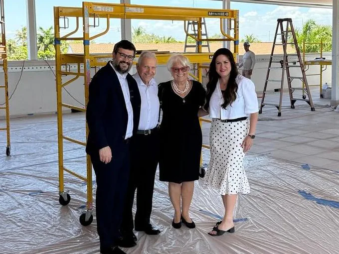 Four people standing together inside the new building while it is being finished