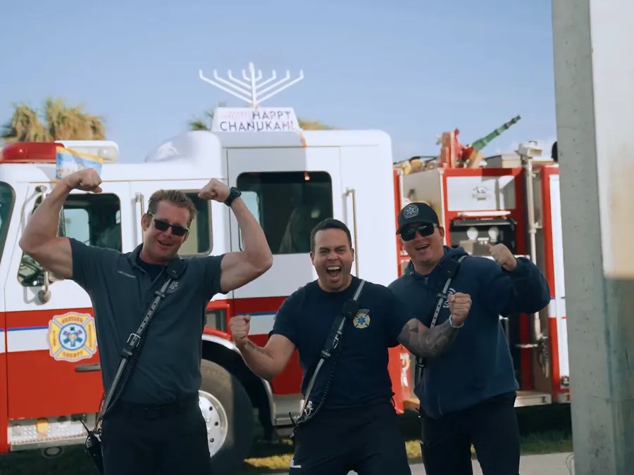 Firefighters with a menorah on their fire truck